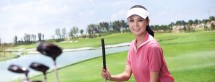 Young woman holding golf clubs