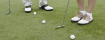 Low section of couple's feet playing golf